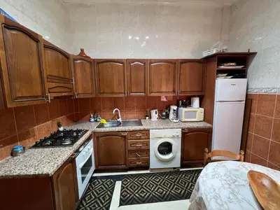 a kitchen with wooden cabinets and a white refrigerator at Apartment NE 4 by Majestic Properties in Marrakech
