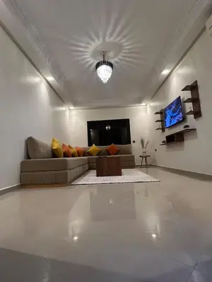 a living room with a couch and a tv at Appartement familière luxe hay menara in Marrakech