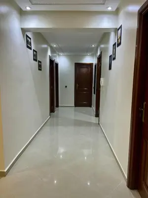 a hallway with white walls and a hallway with brown doors at Appartement familière luxe hay menara in Marrakech