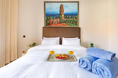 a tray of food on a bed with two glasses at Wintering I Authentic Accommodation I Pool in Marrakech
