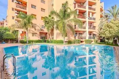 a swimming pool in front of a building with palm trees at Wintering I Authentic Accommodation I Pool in Marrakech