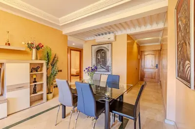 a dining room with a glass table and blue chairs at Wintering I Authentic Accommodation I Pool in Marrakech