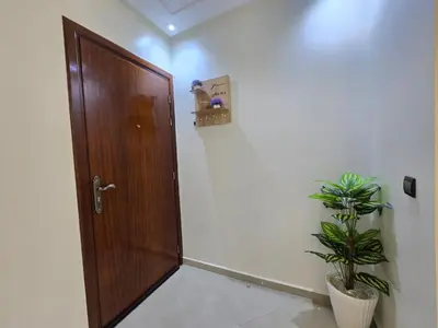 a wooden door in a room with a plant at Appartement de luxe, Marrakech Menara in Marrakech