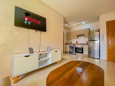 a kitchen with a tv on the wall and a table at Opera hivernage in Marrakech