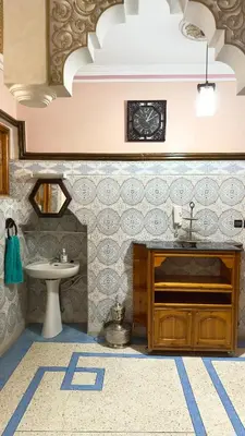 a bathroom with a sink and a clock on the wall at Cozy Garden Home in Marrakech in Marrakech
