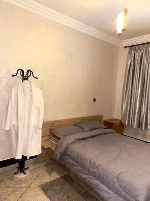 a bedroom with a bed and a robe hanging on a rack at Cozy Garden Home in Marrakech in Marrakech