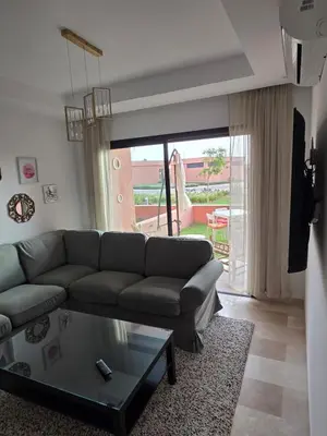a living room with a couch and a glass table at Appartement Résidence Noria Marrakech in Marrakech