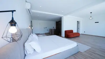 a bedroom with a white bed and a red chair at Villa Adam in Oulad Akkou
