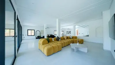 a living room with a yellow couch and a table at Villa Adam in Oulad Akkou