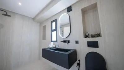 a bathroom with a black sink and a mirror at Villa Adam in Oulad Akkou