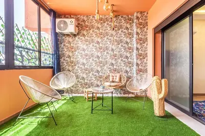 a room with chairs and a table and grass at Gueliz Comfort Corner Urban Apt in Marrakech