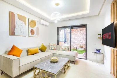 a living room with a couch and a table at Gueliz Comfort Corner Urban Apt in Marrakech