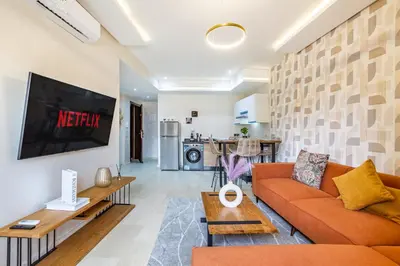 a living room with a couch and a tv at Gueliz Stay modern apt in Marrakech