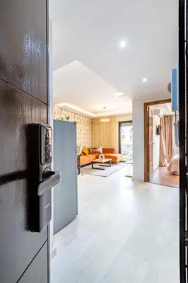a kitchen with a refrigerator and a living room at Gueliz Stay modern apt in Marrakech