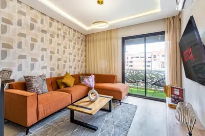 a living room with a couch and a tv at Gueliz Stay modern apt in Marrakech