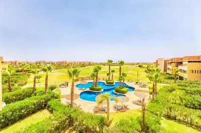 an aerial view of a resort with a pool and palm trees at Luxurious 3BR by to the pool in Marrakech