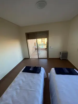 two beds in a room with a view of a patio at Luxury apartment with 2 pools in Marrakech