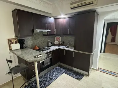 a kitchen with wooden cabinets and a counter top at Modern One Bedroom Apartment in Central Gueliz Marrakech in Marrakech