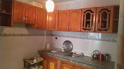 a kitchen with wooden cabinets and a sink at Marrakech Allal El Fassi in Marrakech