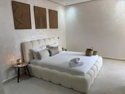 a bedroom with a large white bed with a large couch at Majorelle Retreat - Luxury Studio in Marrakech
