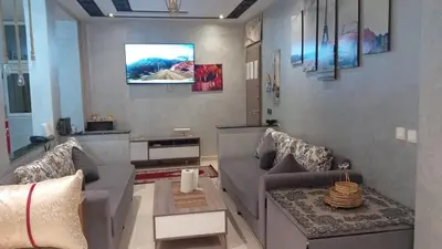 a living room with a couch and a tv on the wall at Cozy Flat near Gueliz in Center in Marrakech