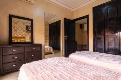 a bedroom with two beds and a dresser and a mirror at Apartment for rent Wintering in Marrakech
