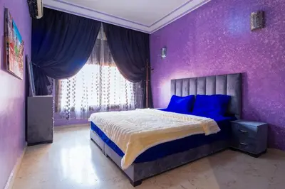 a bedroom with purple walls and a bed with blue pillows at Apartment for rent Wintering in Marrakech