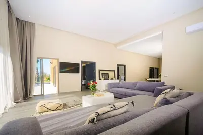 a large living room with two purple couches at Villa Djamila Marrakech in Marrakech