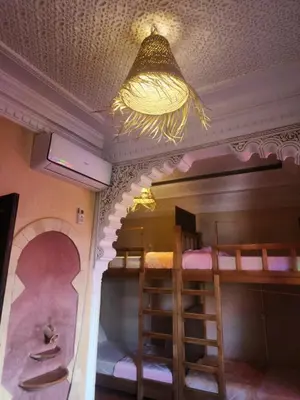 a room with two bunk beds and a chandelier at Riad Hostel ADI in Marrakech