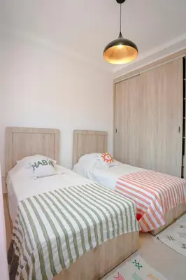 two beds sitting next to each other in a bedroom at 6-person appartment, terrace and spa in Marrakech