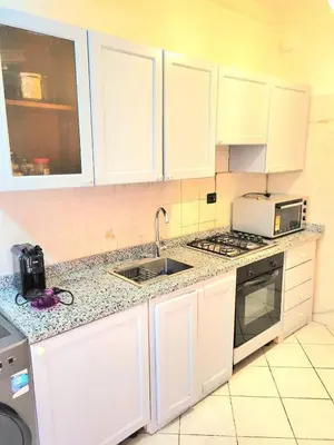 a kitchen with white cabinets and a sink and a microwave at Guéliz Marrakech 2,central, spacieux, Authentique in Marrakech