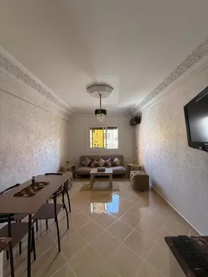 a living room with a table and a couch at Appartement Aeropuerto in Marrakech