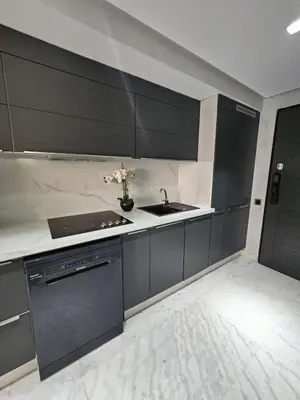 a kitchen with black cabinets and a sink at Loft confort, lumineux, avec accès piscine dans une résidence sécurisée in Marrakech