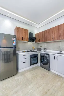 a kitchen with white cabinets and a washer and dryer at -New- Appartement stylé au cœur de Marrakech in Marrakech