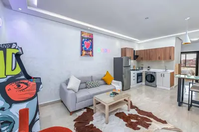 a living room with a couch and a kitchen at -New- Appartement stylé au cœur de Marrakech in Marrakech