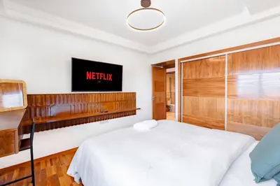 a bedroom with a bed and a tv on the wall at Studio avec piscine et lumières d'ambiance in Marrakech