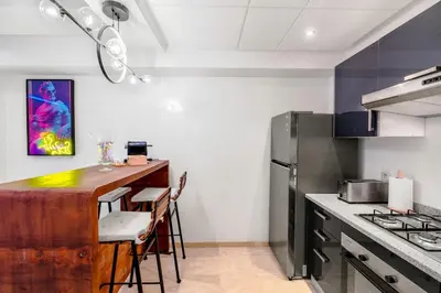 a kitchen with a counter and a bar with stools at Studio avec piscine et lumières d'ambiance in Marrakech