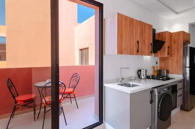 a kitchen with a sink and a table with chairs at Apartment in Guéliz with cozy terrace in Marrakech