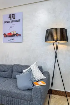 a living room with a blue couch and a lamp at Condo in Gueliz inspired by motorsports in Marrakech