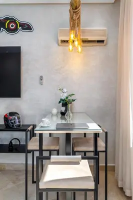 a dining room with a white table and chairs at Condo in Gueliz inspired by motorsports in Marrakech