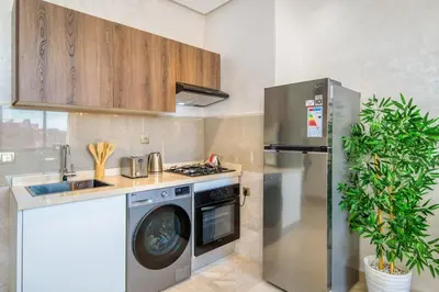 a kitchen with a washing machine and a refrigerator at Condo in Gueliz inspired by motorsports in Marrakech