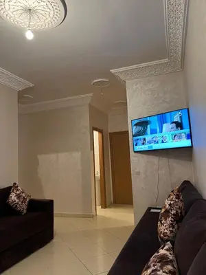 a living room with a couch and a flat screen tv at Appartement Marrakech au 1er étage in Marrakech