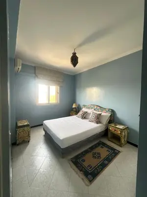 a bedroom with a white bed and a window at Appartement Layane Votre havre de paix à deux pas de Guéliz in Marrakech