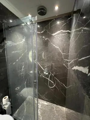 a shower with a glass door in a bathroom at Elite Garden Grand Studio Luxe in Marrakech