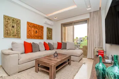 a living room with a couch and a table at Chic & Cozy Apartment with Pool View - Prestigia in Marrakech