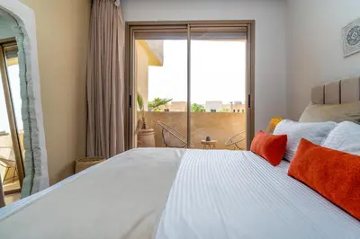 a bedroom with a large bed with a large window at Chic & Cozy Apartment with Pool View - Prestigia in Marrakech