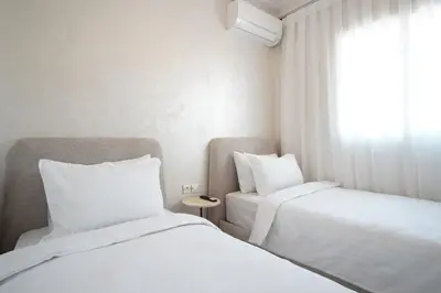 two beds in a small room with a window at New cozy 2 bedroom apartment with 3 ACs close to airport and center in Marrakech