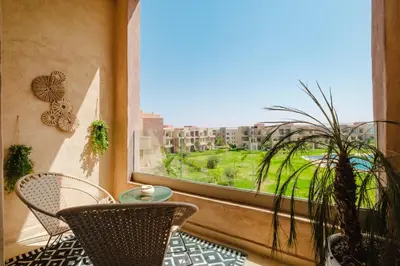 a balcony with a table and chairs and a window at Appartement de charme residence avec piscine WiFi in Marrakech