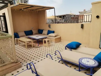 a patio with a couch and a table and chairs at Riad Médina Bienvenue in Marrakech
