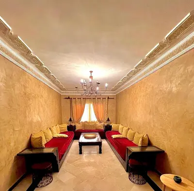 a large living room with red couches and a chandelier at Élégance & fraîcheur Appart avec piscine in Marrakech